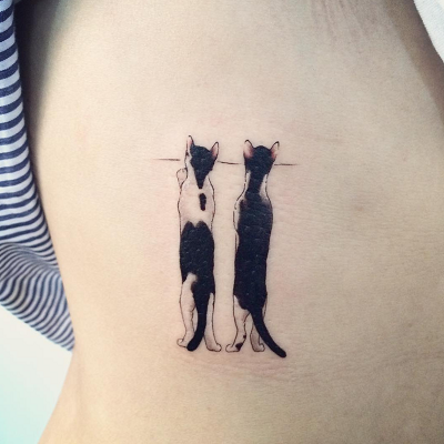 tatuagem de dois gatos espiando