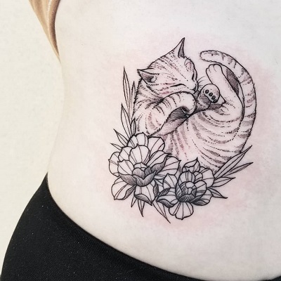 tatuagem de gato dormindo sobre flores